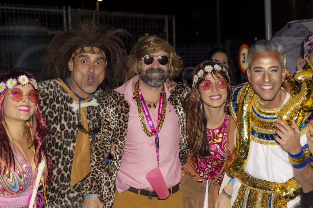 Fiesta nocturna del Carnaval de Tenerife en la Plaza de España, con luces en el escenario, disfraces coloridos y miles de personas.