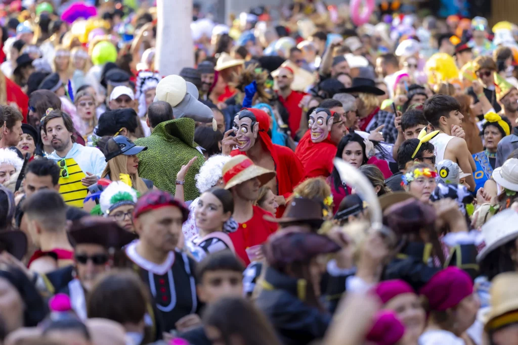 Fiesta callejera del Carnaval de Tenerife 2026 con trajes coloridos y multitudes bailando en la Plaza de España de Santa Cruz